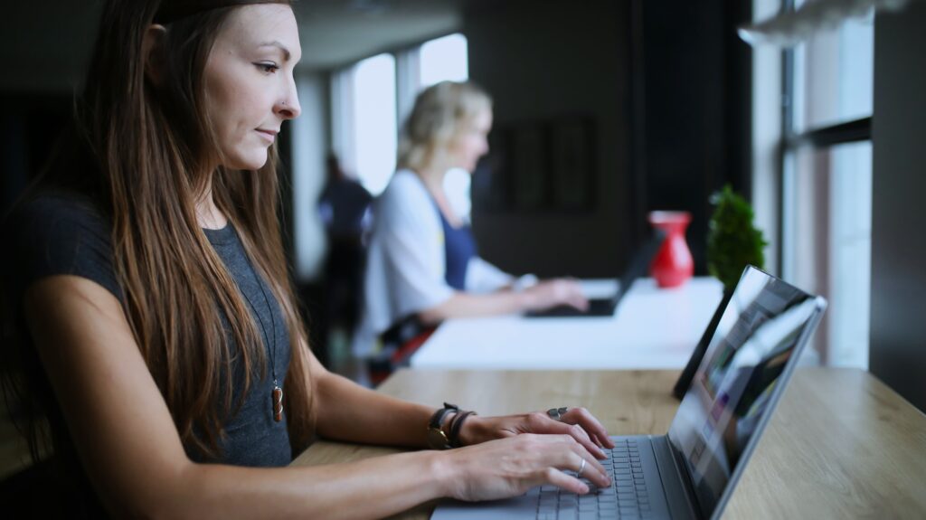 An employer working on a laptop in a modern office environment, focusing on maintaining their core responsibilities while GloballyHired’s EOR services handle HR and administrative tasks.