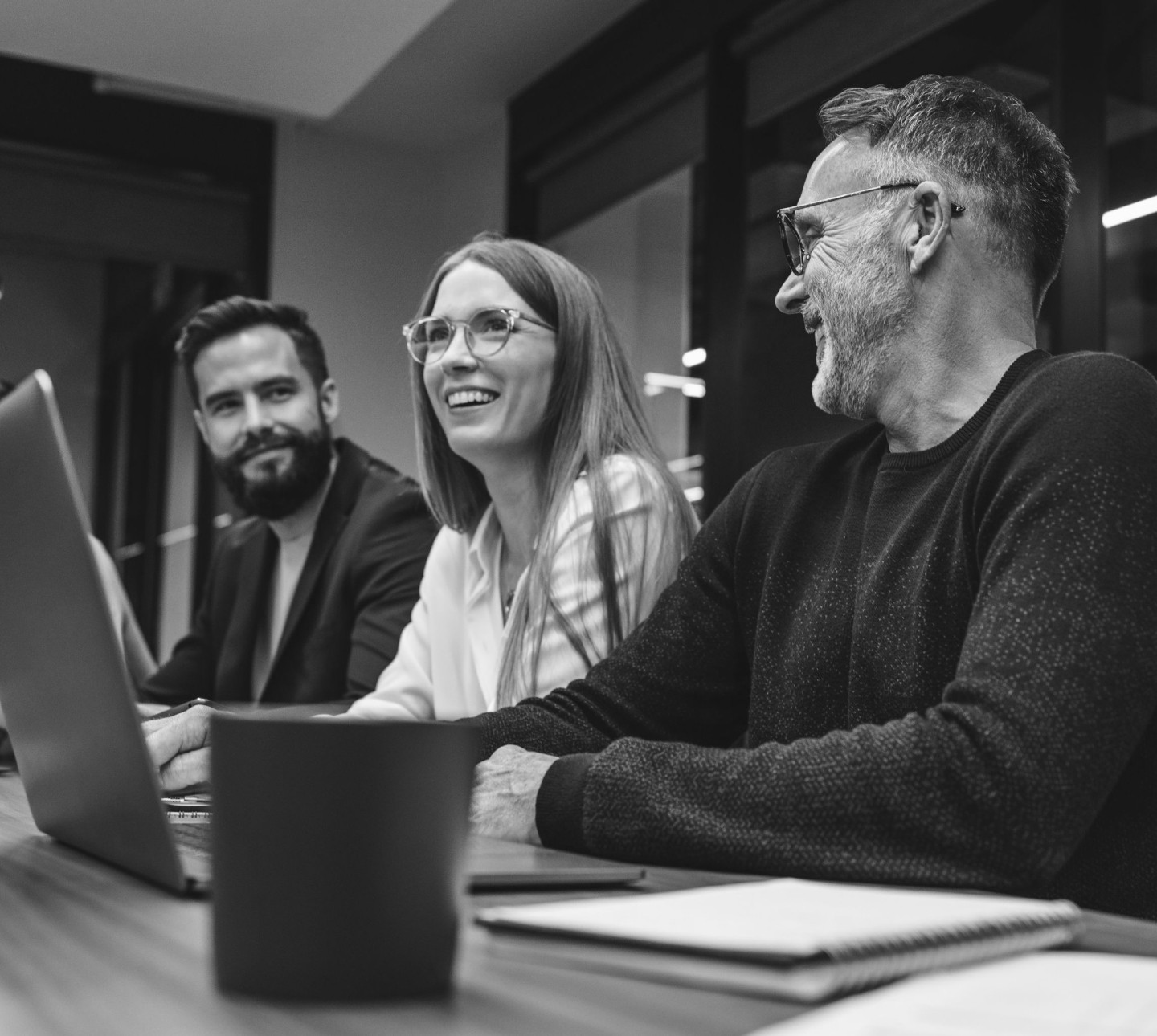 Three on-demand temporary workers at a conference table laughing