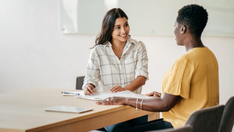 Two professional woman sitting at a table having a meeting