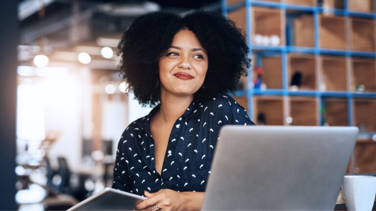 African-american woman business professional sitting at a desk with laptop